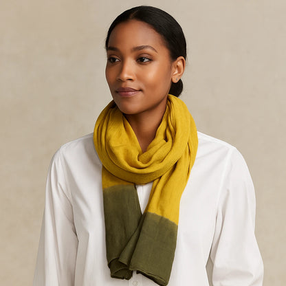 Woman wearing a mustard yellow and green scarf on a beige background