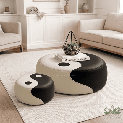 Two round pouf ottomans with a black and cream yin-yang design, styled in a bright, modern living room setting.
