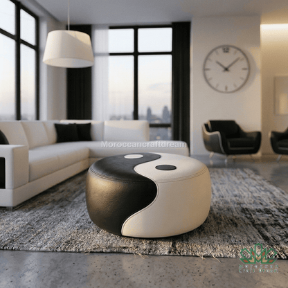 A modern round ottoman with a black and white yin-yang design, styled in a contemporary living room setting on a gray rug.