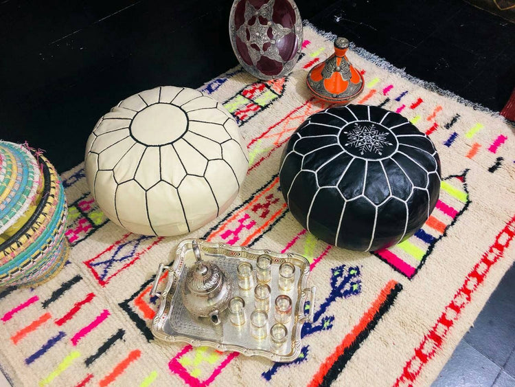 Black and cream handmade round Moroccan pouf ottoman in genuine leather, perfect for use as a versatile coffee table or footrest. This Moroccan leather ottoman enhances living room decor with its elegant design and multifunctional use. Crafted from high-quality leather, Moroccancraftdream's leather poufs offer a stylish and practical solution for modern living spaces. Ideal for use as a coffee table or seating, this round pouf adds a touch of sophistication to any room