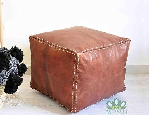 Handcrafted leather Moroccan poufs, ottomans and footstool in natural tones, featuring traditional stitching and soft, durable materials.