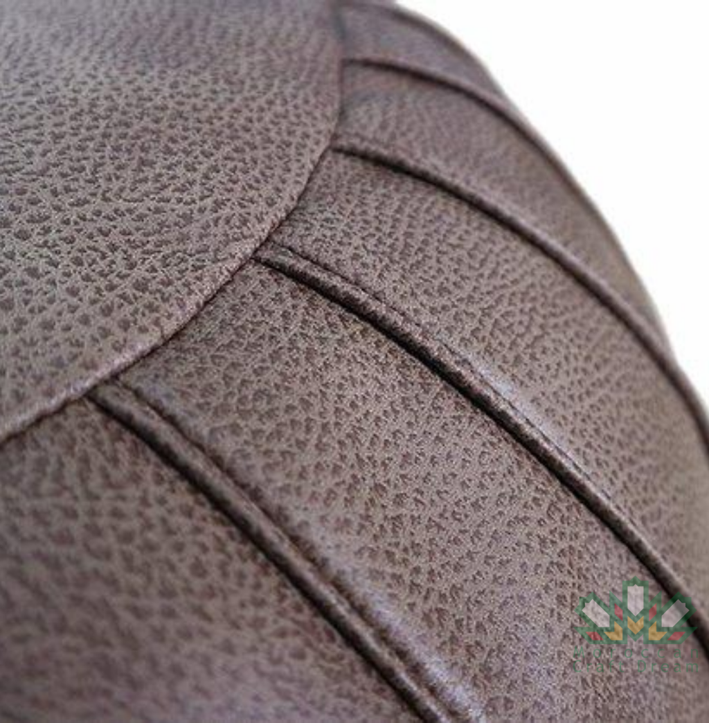 Round grey Handcrafted Moroccan leather pouf for living room decor, blending comfort with authentic Moroccan style.