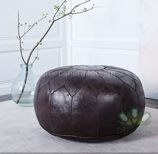 Round Moroccan coffee tables leather poufs used as a coffee table, handcrafted with durable materials and traditional stitching in natural tones.