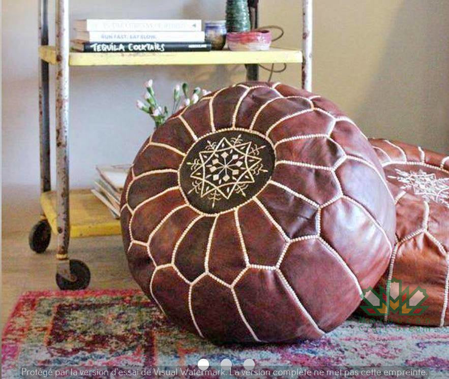 Round Moroccan leather poufs used as a coffee table, handcrafted with durable materials and traditional stitching in natural tones.