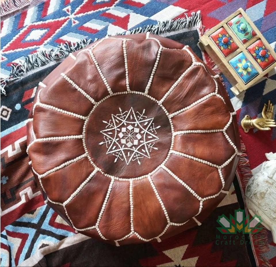 Round Moroccan leather poufs used as a coffee table, handcrafted with durable materials and traditional stitching in natural tones.