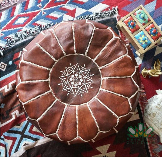 Round Moroccan leather poufs used as a coffee table, handcrafted with durable materials and traditional stitching in natural tones.