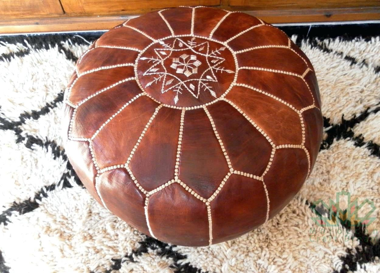 Round Moroccan leather poufs used as a coffee table, handcrafted with durable materials and traditional stitching in natural tones.