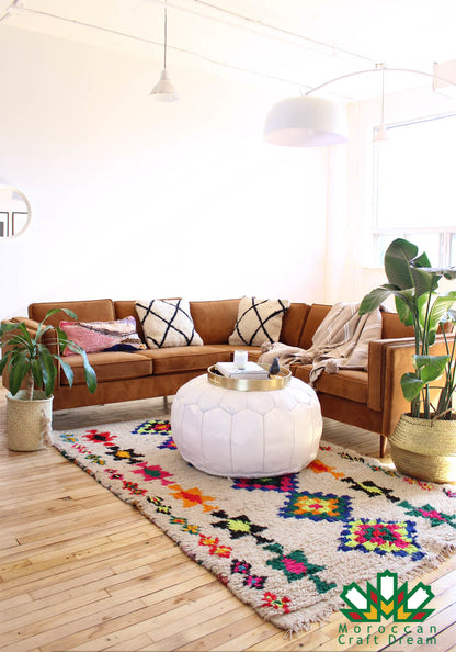 Round Moroccan leather poufs used as a coffee table, handcrafted with durable materials and traditional stitching in natural tones.