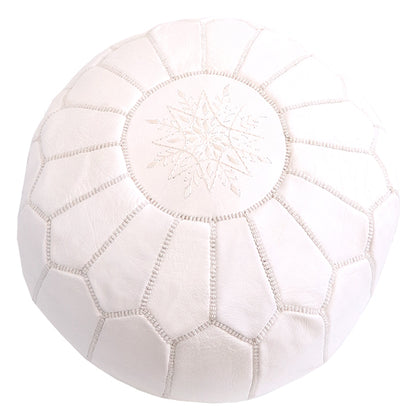 Round Moroccan leather poufs used as a coffee table, handcrafted with durable materials and traditional stitching in natural tones.