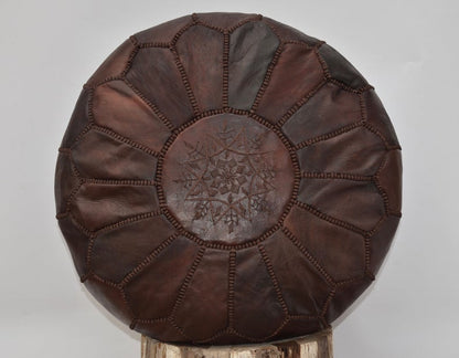 Luxurious brown leather Moroccan pouf ottoman by Moroccancraftdream, used as a footrest or extra seating option.