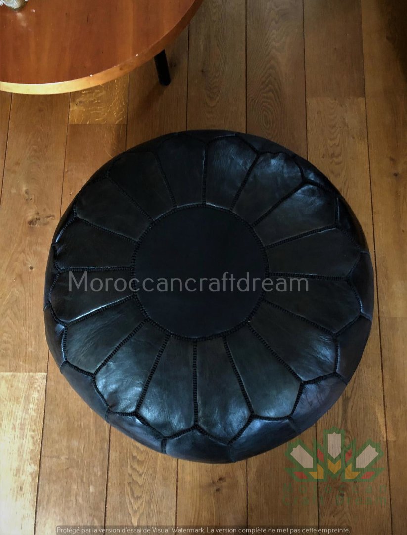 Black Versatile Moroccan leather pouf ottoman, suitable as additional seating, footrest, or stylish coffee table.