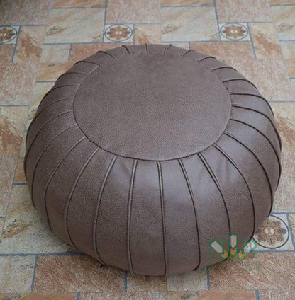 Round Handcrafted Moroccan leather pouf for living room decor, blending comfort with authentic Moroccan style.