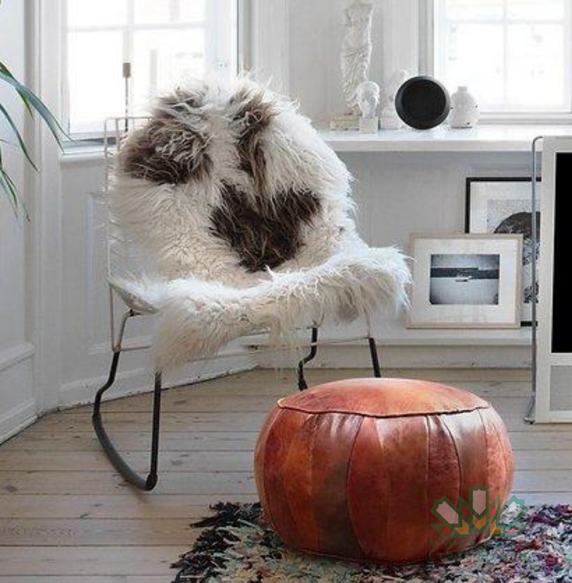 Round leather moroccan pouf used as a coffee table, handcrafted with durable materials and traditional stitching in natural tones.