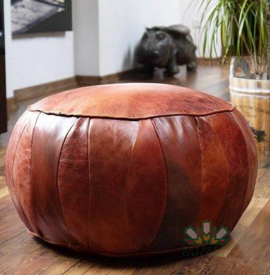 Round leather moroccan pouf used as a coffee table, handcrafted with durable materials and traditional stitching in natural tones.